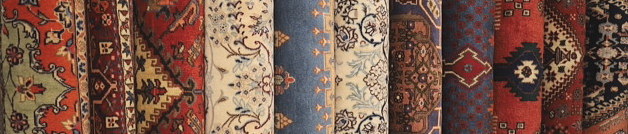 さまざまな産地のペルシャ絨毯が丸めて並べられた様子