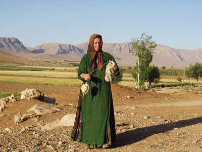 糸を紡ぐ、緑のドレスの女性