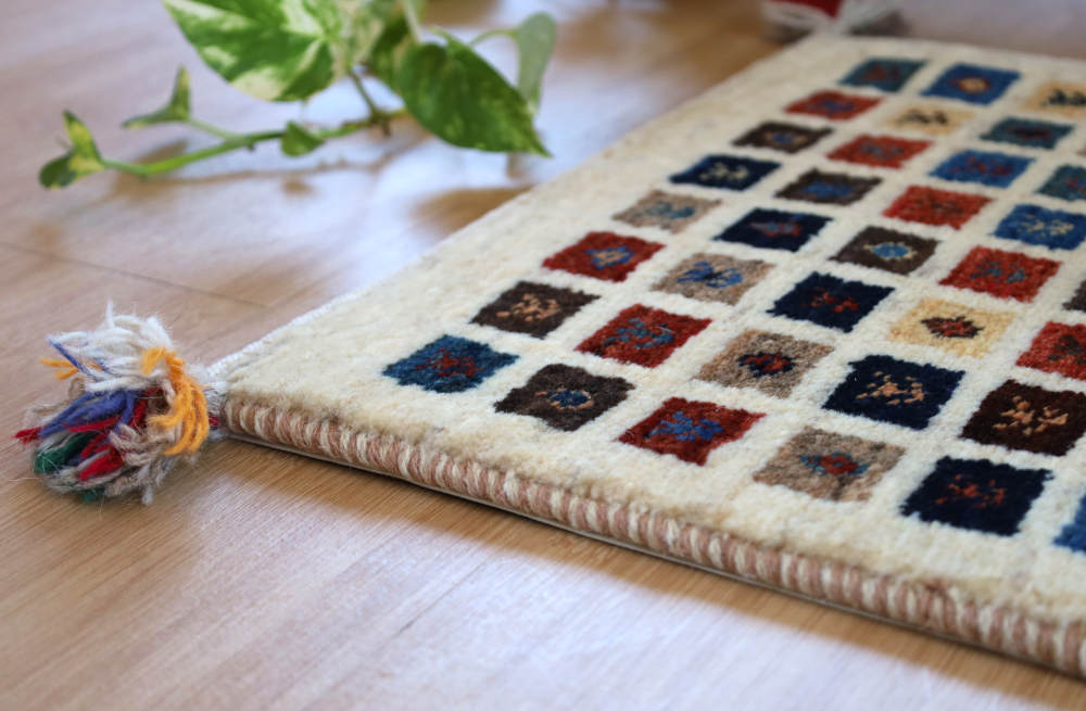 ファイン・ギャッベ（カシュクリ）のミニマット　アイボリー×ミックス色　56×42cm 端部分を近くでみたところ