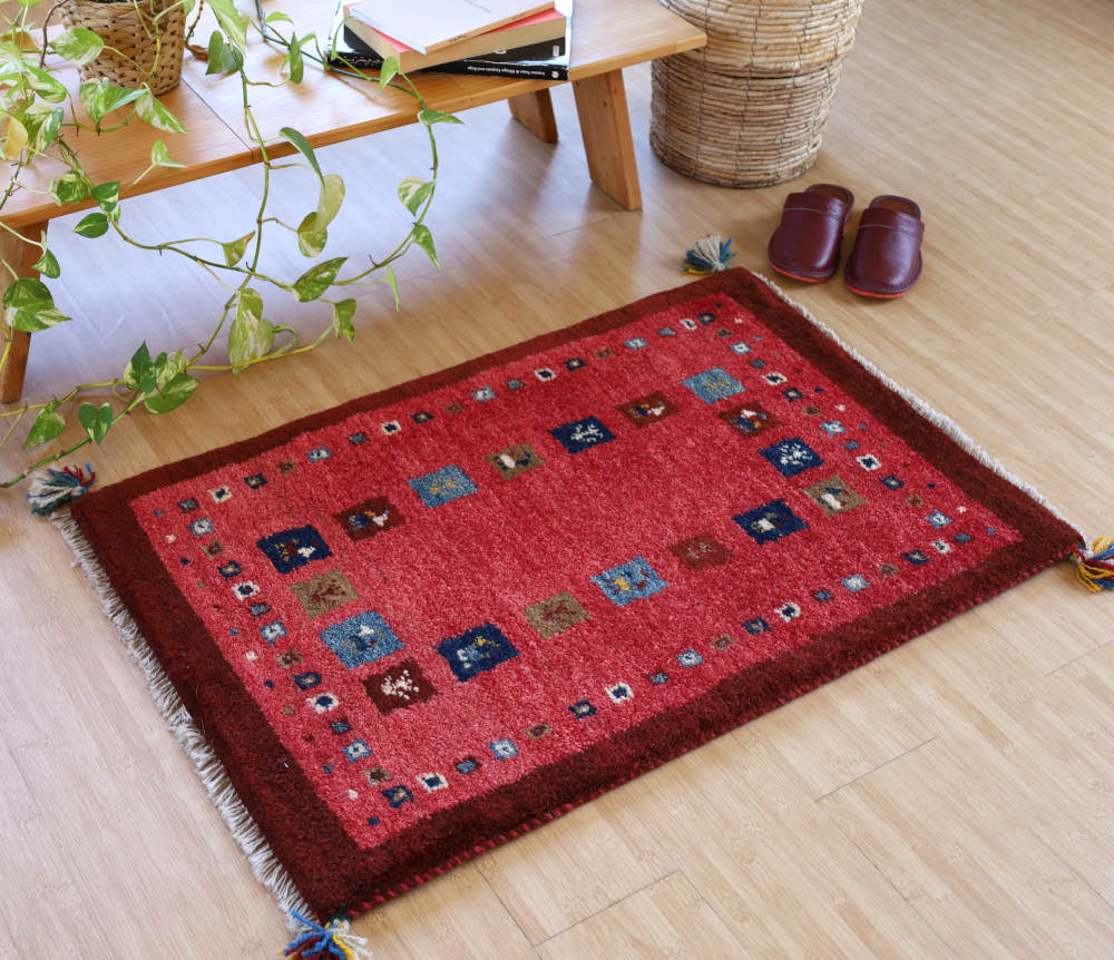 えんじ×薄赤のギャッベ玄関マット（93×61cm）をナチュラルな色の床に敷いたところ