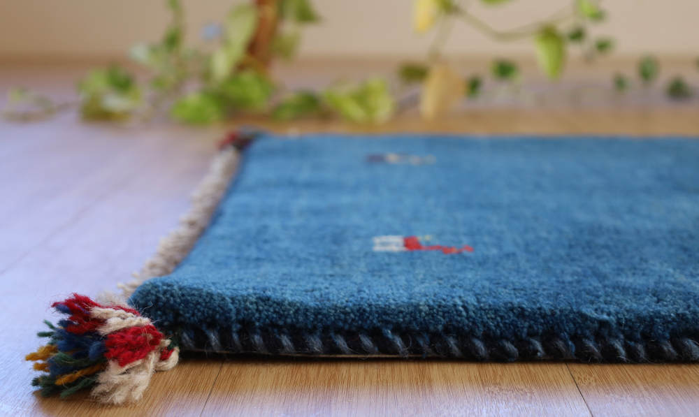 青いギャッベの玄関マット　91×61cm　厚みを横から見たところ