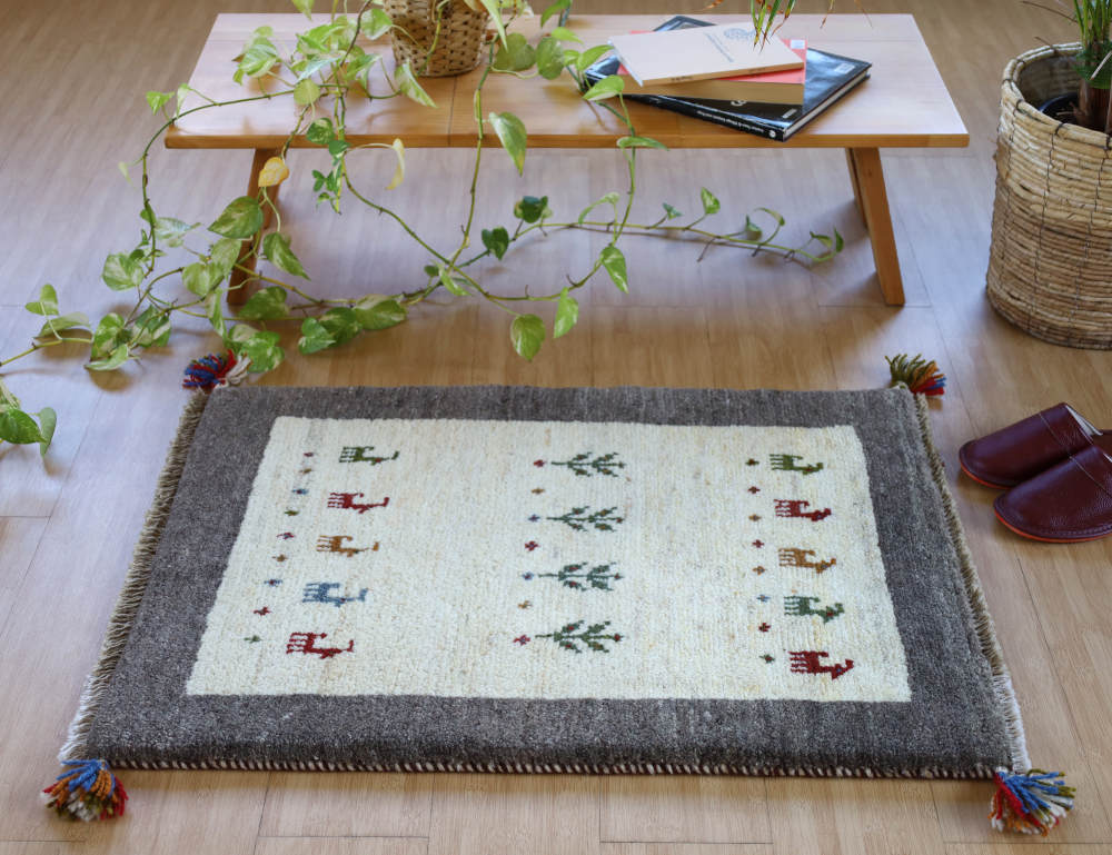 グレーとアイボリーのギャッベ玄関マット（86×62cm）をナチュラルな色の床に敷いたところ