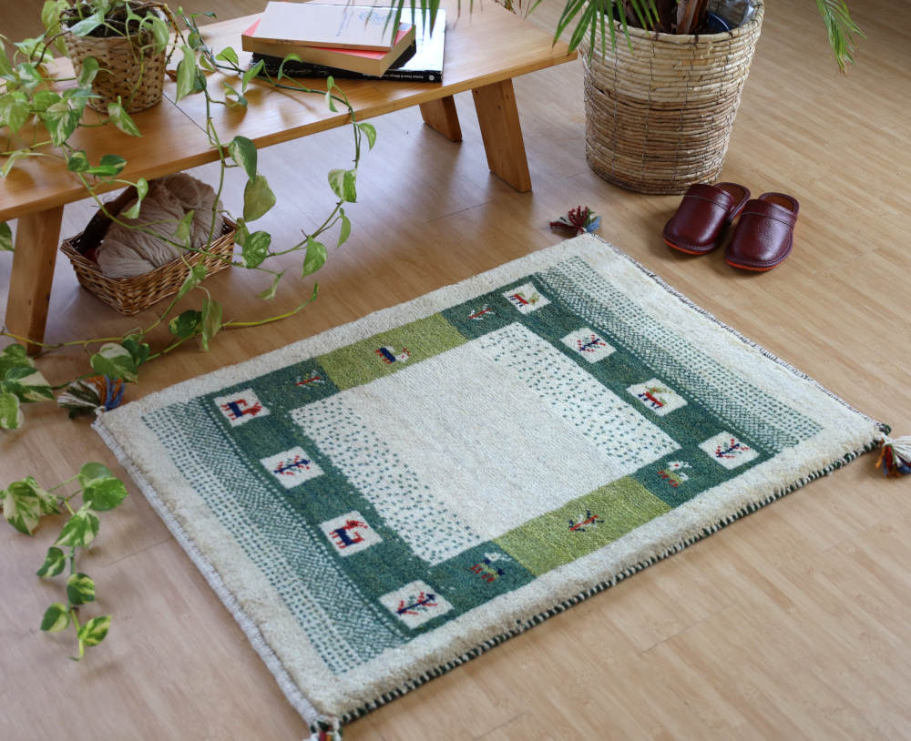 アイボリー×緑のギャッベ玄関マット（89×62cm）を明るい色の床に敷いたところ