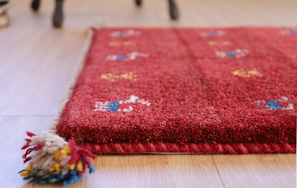 赤いギャッベ玄関マット　82×59cm　厚みを横から見たところ