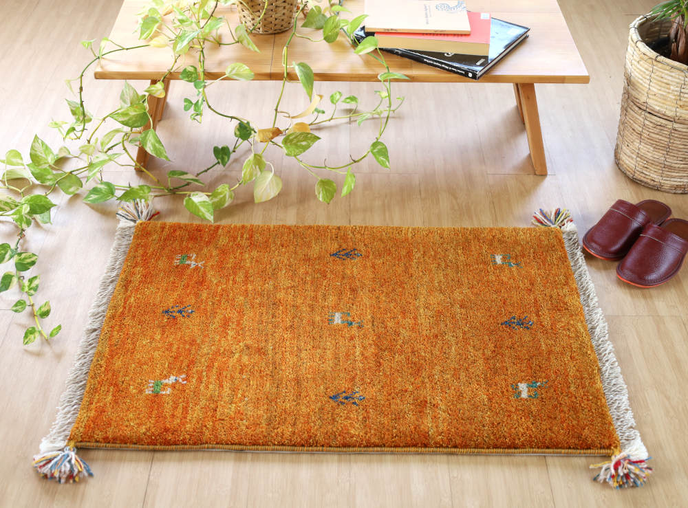 オレンジ色のギャッベ玄関マット（87×58cm）をナチュラルな色の床に敷いたところ