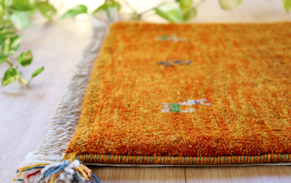ギャッベ玄関マット　87×58cm　オレンジ色　厚みを横から見たところ