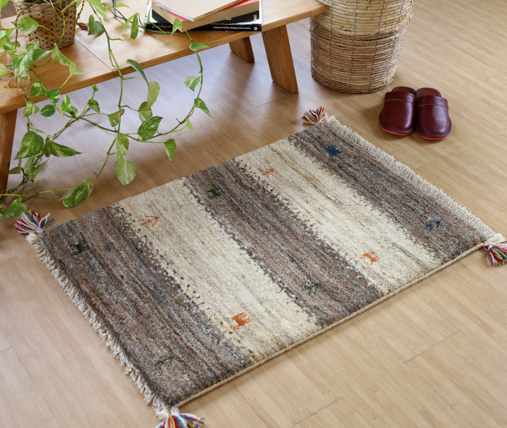 アイボリーと茶のギャッベ玄関マット（85×59cm）をナチュラルな色の床に敷いたところ