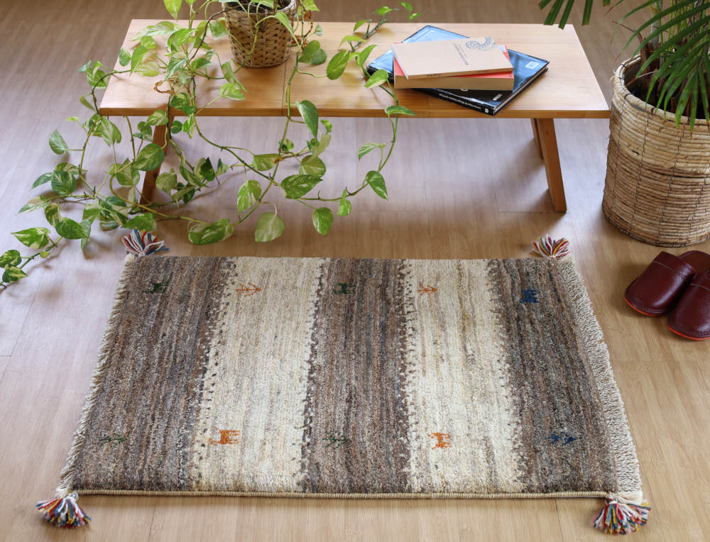 アイボリーと茶のギャッベ玄関マット（85×59cm）をナチュラルな色の床に敷いたところ