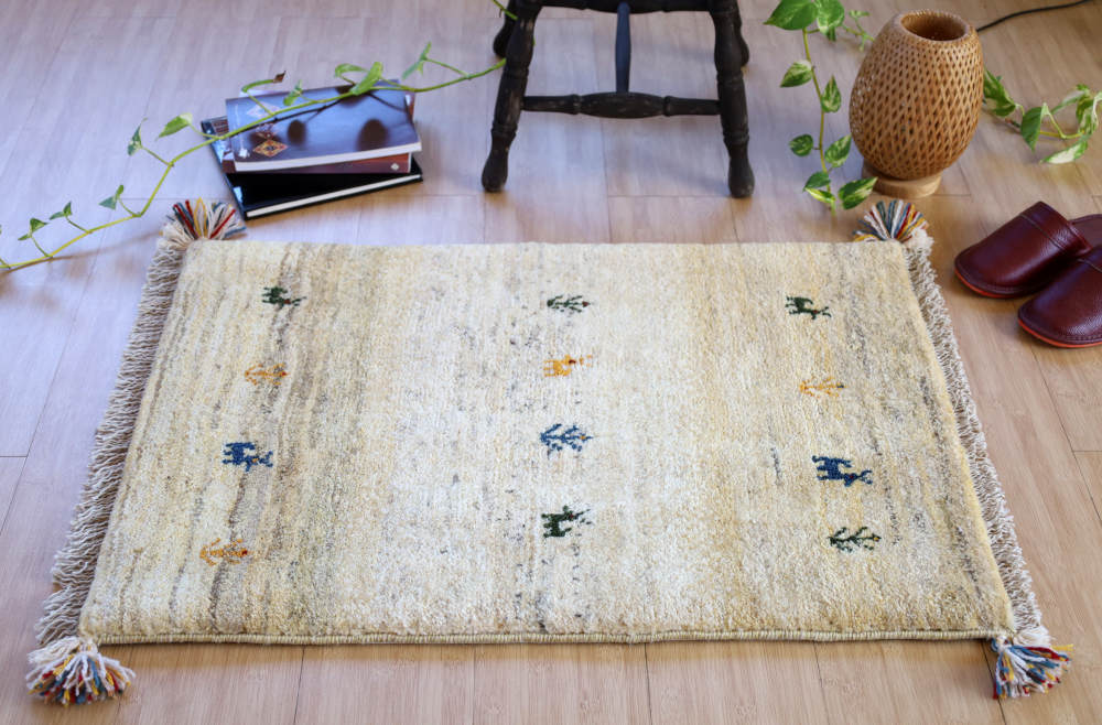 アイボリーのギャッベ玄関マット（85×59cm）をナチュラルな色の床に敷いたところ