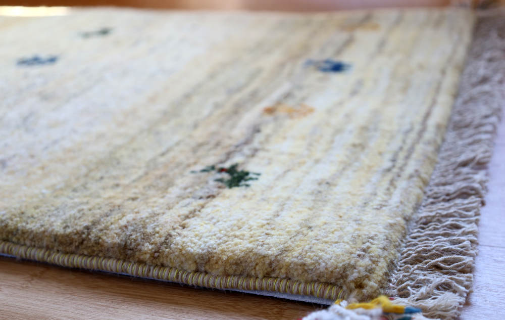 アイボリーのギャッベ玄関マット　85×59cm　厚みを横から見たところ
