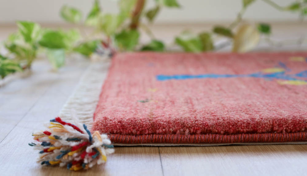 ざくろの模様のギャッベ玄関マット　94×58cm　ピンク　厚みを横から見たところ